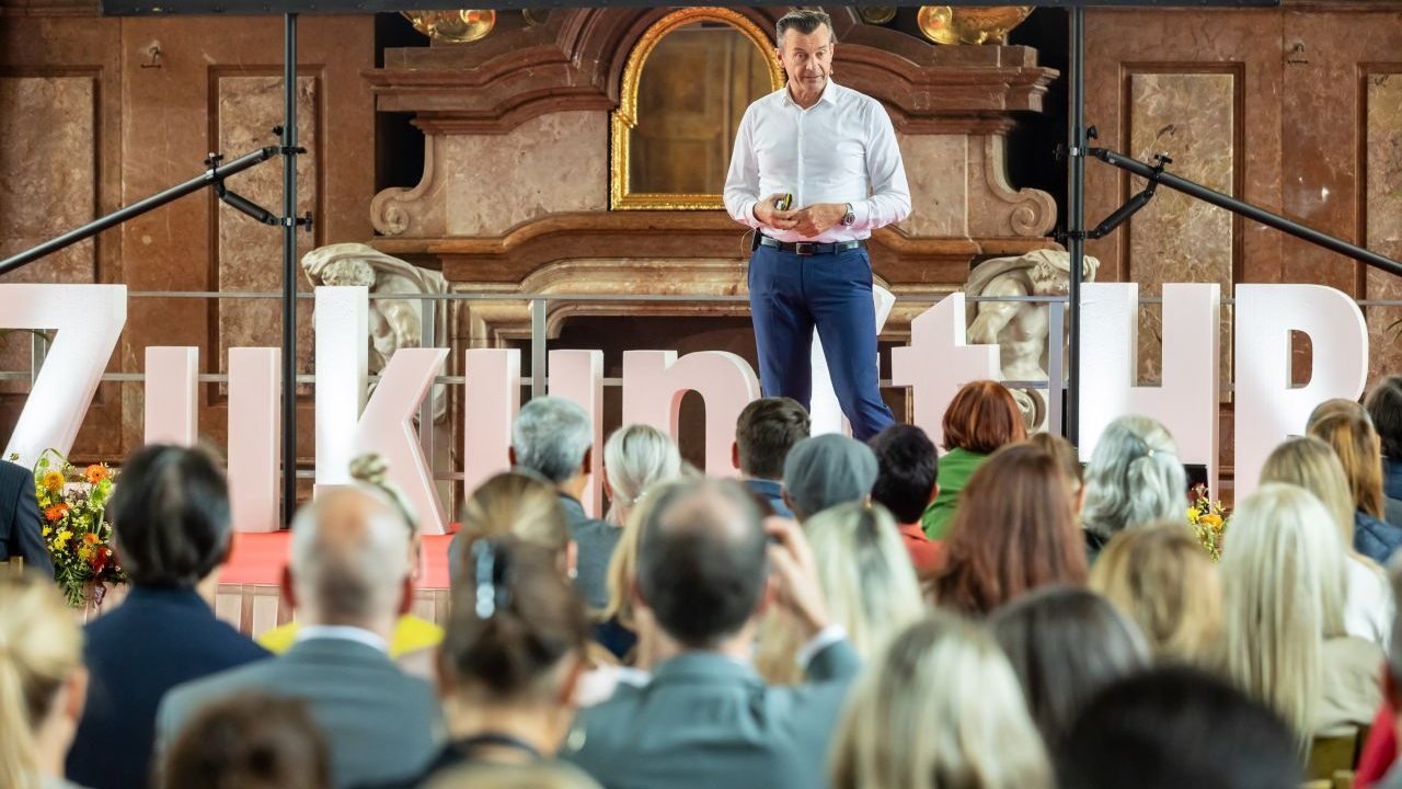 Gerhard Kürner in front of a full hall at Zukunft.HR in St. Florian Monastery
